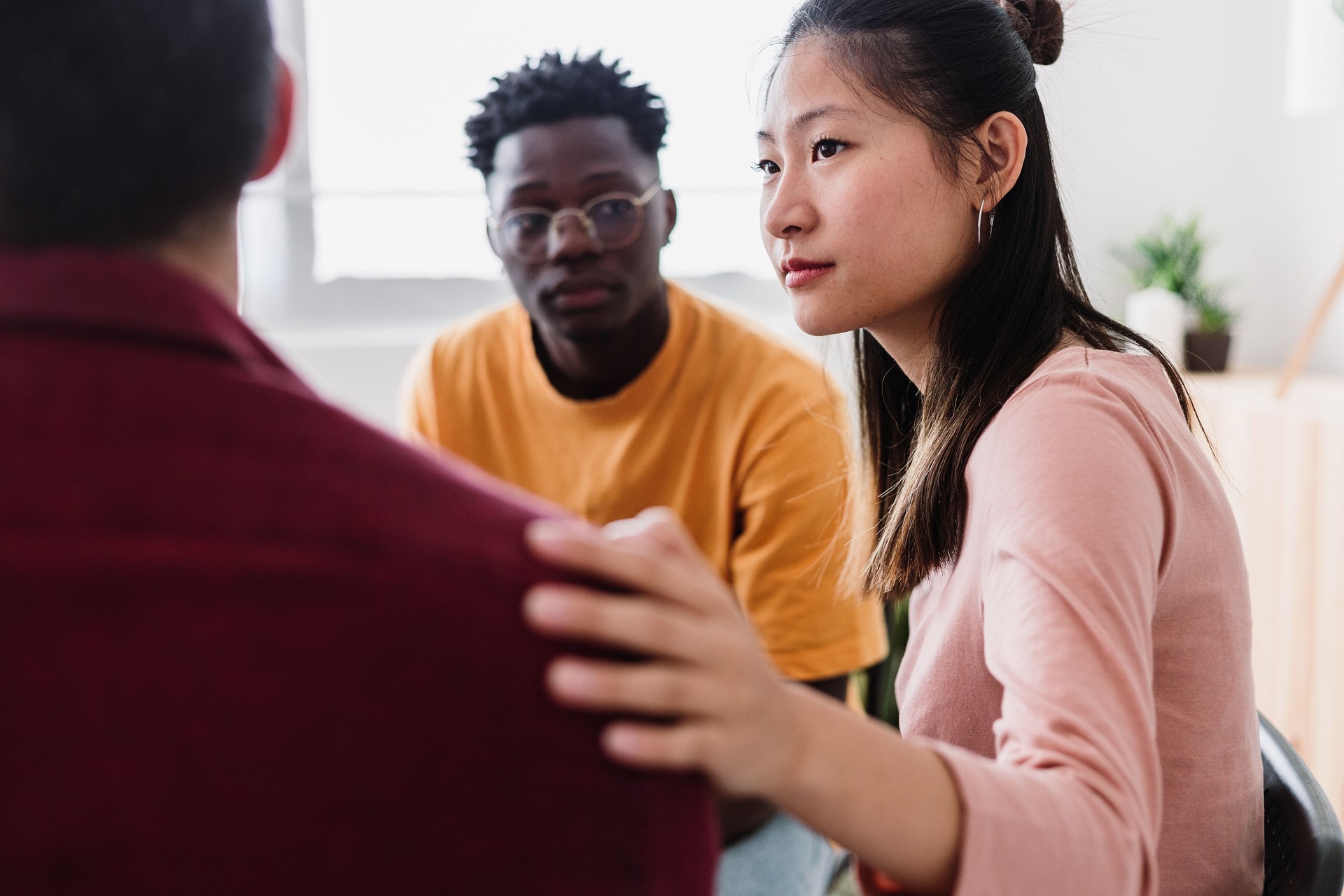 Meeting of young people in group therapy supporting each other.